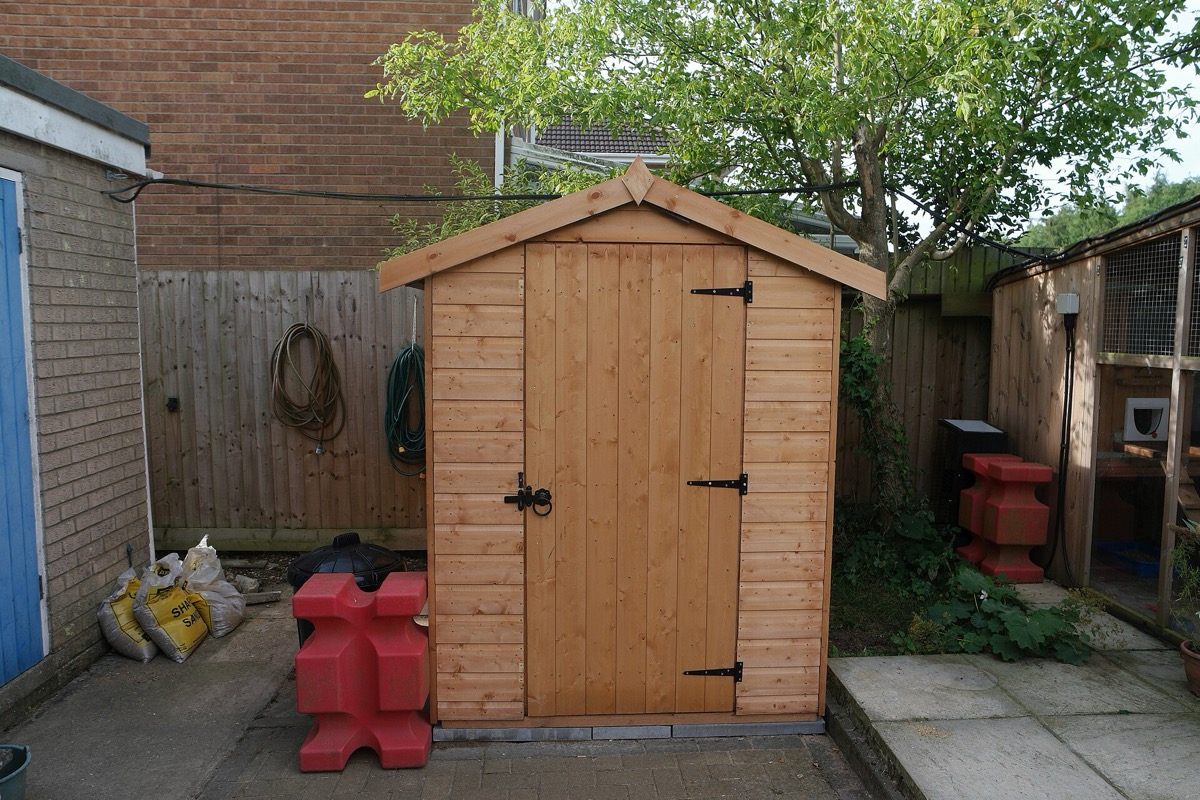 A wooden garden shed in a back yard
